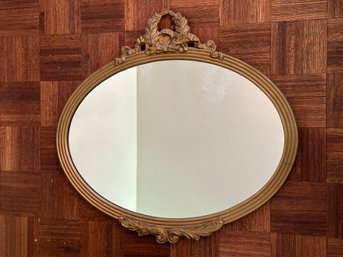 An Antique Oval Wall Mirror With A Gilt Finish