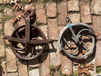 TWO ANTIQUE CAST IRON PULLIES