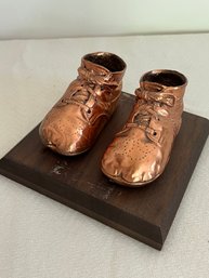 Bronzed Baby Shoes On Wooden Platform