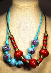 Two 1980s Satin Cord And Pottery Red And Blue Floral Decorated Necklaces