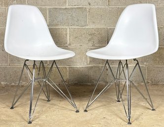 A Pair Of Modern Molded Plastic Chairs On Metal Bases