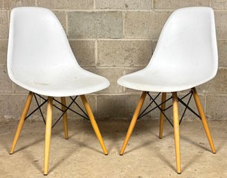 A Pair Of Molded Plastic Chairs With Wood Bases