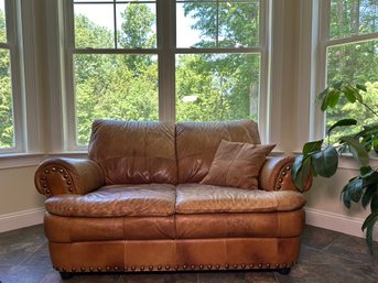 A Leather Love Seat With Nail Head Detail