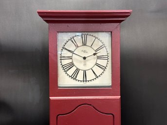 A Wooden Wall Clock In Barn Red