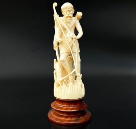 An Antique Japanese Netsuke Carving Of An Archer On A Carved Wood Base