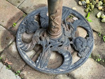 A Cast-Metal Umbrella Holder With A 7' Tan Market Umbrella