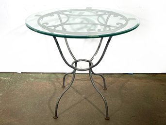 A Wrought Iron And Thick Glass Bistro Or Garden Table