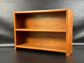 A Small Display Stand With Two Shelves In Cherry