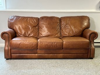 A Three Seat Sofa In Faux Leather With Rolled Arms & Nailhead Trim