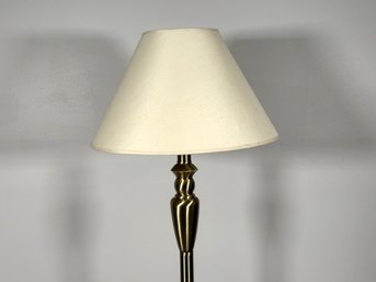 A Floor Lamp With A Brushed Brass Finish, Weighted Base & Bell Shade