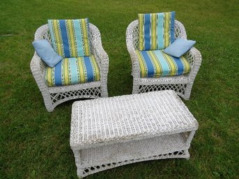 Two White Wicker Chairs And A Table