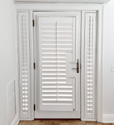 A Full Glass Exterior Door With Two Side Lights And Interior Shutters