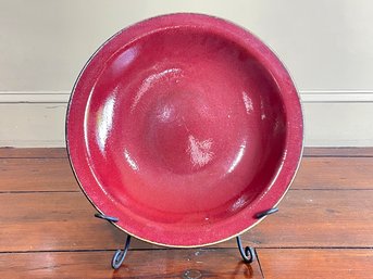 A Large Glazed Earthenware Serving Platter With Metal Stand