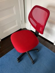 A Red Mesh Desk Chair On Casters