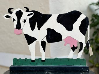 A Hand Painted Wood Cow Cutout On Stand