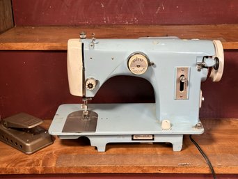 A Vintage Sewing Machine In Light Blue