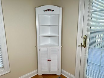 A Pretty White Corner Cabinet With Floral Embellishment