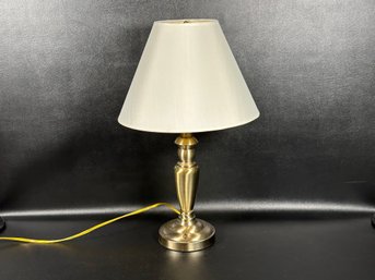 A Table Lamp With A Brushed Brass Body & Bell Shade