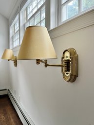 A Pair Of Brass Toned Swing Arm Sconces With Clip On Shade