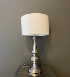 Single Silvertone Table Lamp With White Barrel Shade