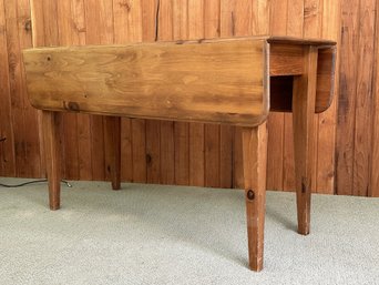 A Vintage Drop-Leaf Table In Knotty Pine