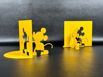 A Whimsical Pair Of Mickey Mouse Bookends In Bright Yellow Metal