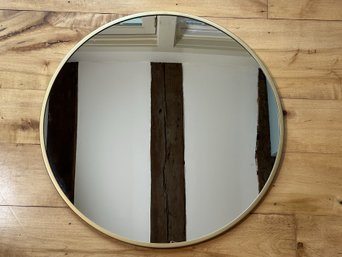 A Modern Round Mirror With A Gold-Toned Metal Frame #1
