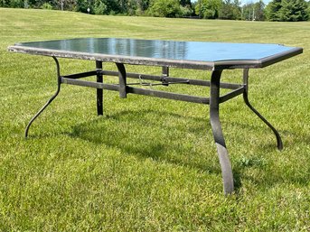 A Tubular Metal And Tempered Glass Outdoor Table