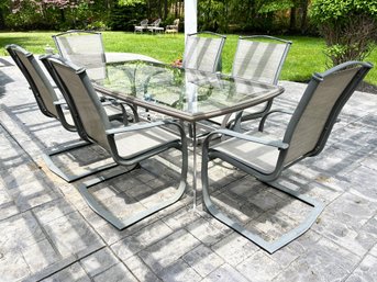 An Outdoor Glass Top Dining Table And Set Of 6 Mesh Chairs By Winston