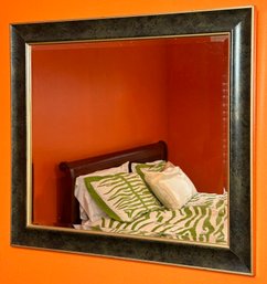 A Beveled Mirror In Decorative Frame