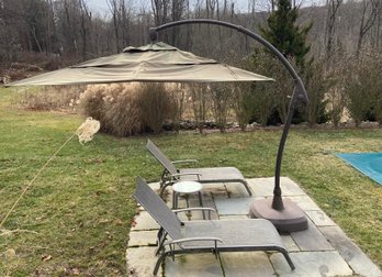 Large Patio Umbrella, Two Chaise Lounge Chairs And A Small Circular Table