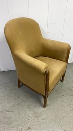 An Antique Round Back Upholstered Armchair With Decorative Wood Trim