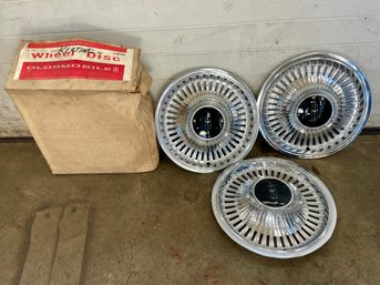 Three NOS Oldsmobile Hubcaps.  (13)