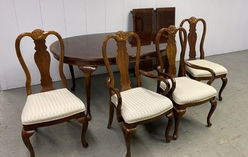 A Classic Banded Oval Dining Table With Four Chairs And Two Leaves