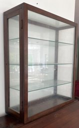 A Vintage Display Cabinet With Glass Shelves.