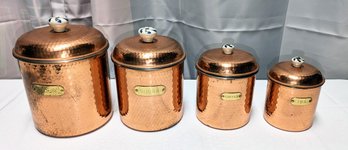 Set Of (4) 1980s Hammered Copper/Nickel Lined Nesting Canisters With Brass Plates & Porcelain Knobs.
