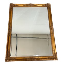 Hanging Gold Tone Wall Mirror With Beveled Edge In A Carved Wood Frame