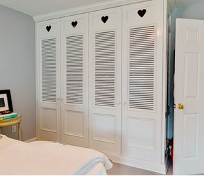 A Custom Wood Wardrobe Cabinet With Heart Cut Outs And Slatted Doors - BR 2D