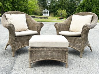 A Pair Of Faux Wicker Arm Chairs And A Cocktail Table With Linen Cushions By Restoration Hardware