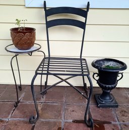 Heavy Wrought Iron Outdoor Chair Paired With Iron Plant Stand Faux Planter And Two Planters