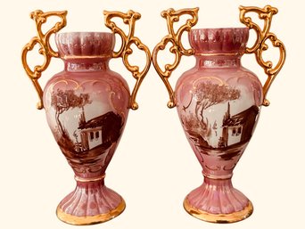 Pair Of Pink Alcobaca Vases Hand Painted Village Scene And With Ornate Scrolled Gold Handles 10 Inches Tall