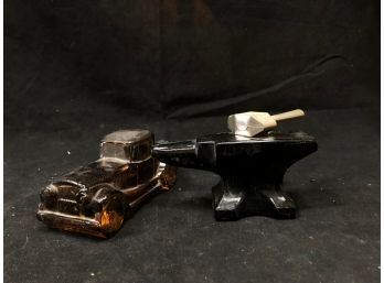 Amber Glass Car Bottle And An Anvil