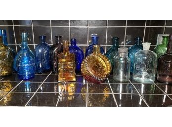 A Large Assortment Of Colored Glass Bottles Including Franklin Mint