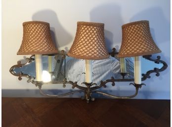 Mirrored Wall Sconce With Three Light Bulbs And Shades