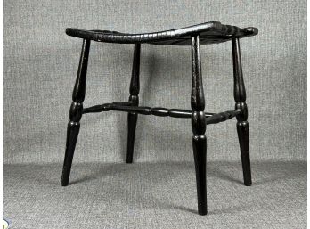 A Vintage Saddle Stool With A Woven Seat