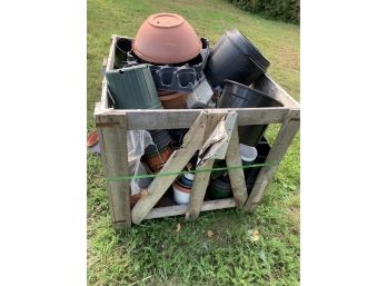 Large Crate Filled With Plastic Planters Of Various Shapes And Sizes