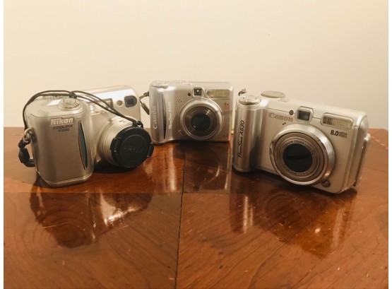 Collection Of Three Hand-Held Cameras