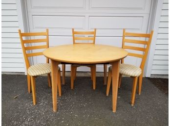 A Modern Hardwood Table And Three Chairs