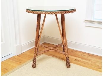 A Wicker And Rattan Occasional Table With Glass Top