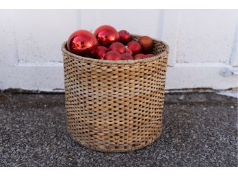 Woven Basket With Collection Of Red Christmas Baubles